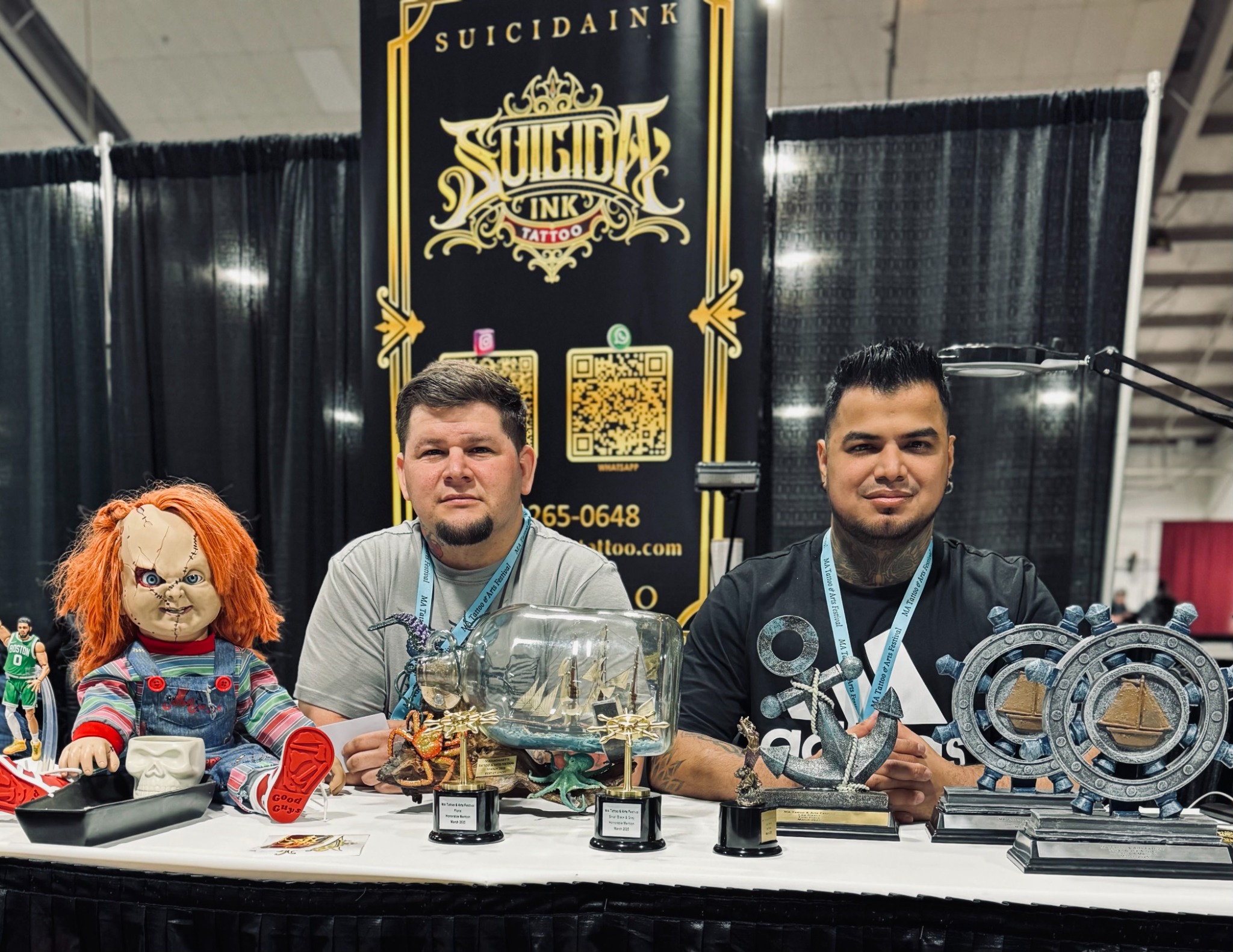 Suicida Ink artists at their convention booth with award trophies